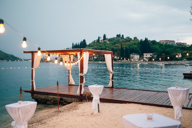 Party on the beach. The pier in the Gulf of Kotor. A gazebo decorated garlands