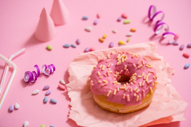 파티. 다채로운 설탕 둥근 유약 도넛. 축하 모자, 반짝이, 사탕
