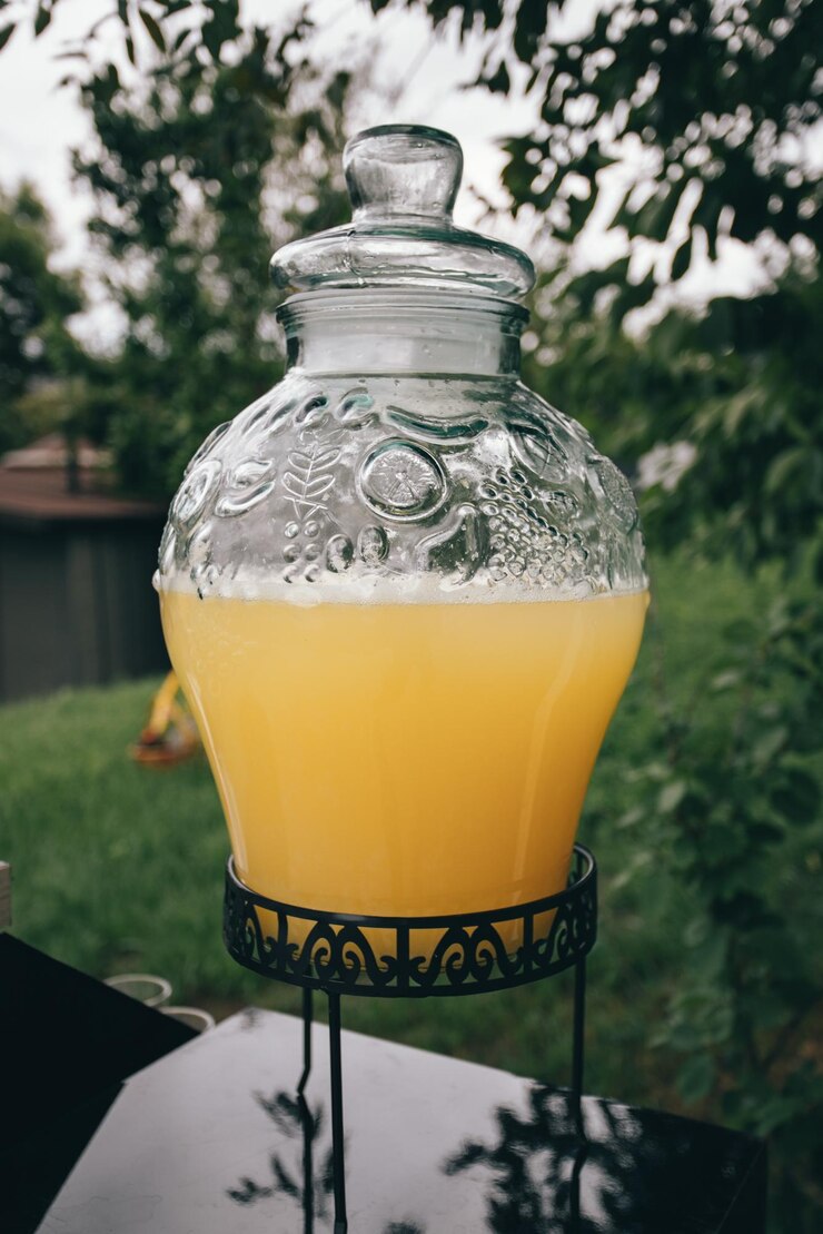 Photo party details. big glass jar with lemonade in the yard