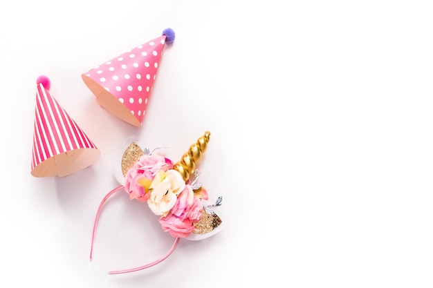 Party hats and unicorn headband on a white background.