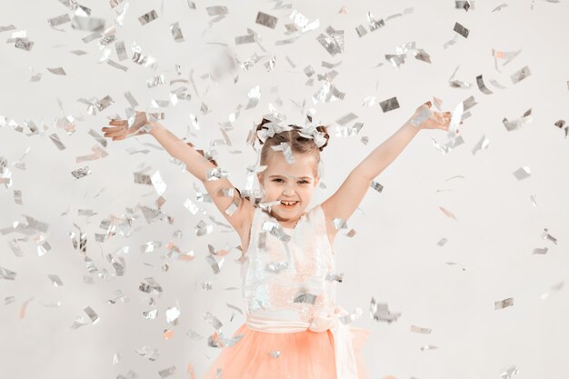 Party, holidays, birthday, new year and celebration concept - Cute child throwing confetti.