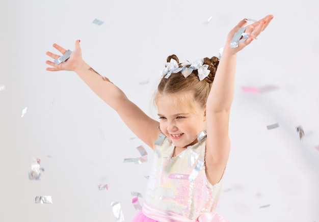 パーティー、休日、誕生日、新年、お祝いのコンセプト-かわいい子供が紙吹雪を投げます。