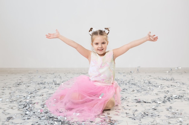 Photo party, holidays, birthday, new year and celebration concept - cute child throwing confetti.