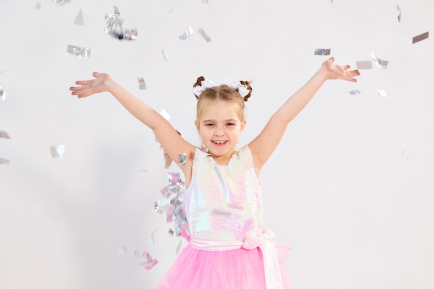 Party, holidays, birthday, new year and celebration concept - Cute child throwing confetti.