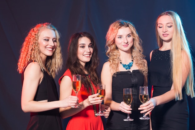 Party, holidays, celebration and new year eve concept - Cheerful young woman clinking glasses of champagne at the party.