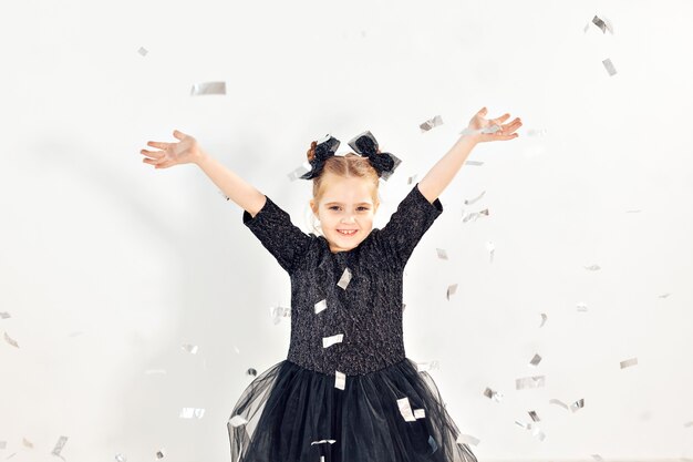 Party, holidays, new year and celebration concept - Female child throwing confetti