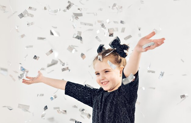 パーティー、休日、新年、お祝いのコンセプト-紙吹雪を投げる女性の子供。