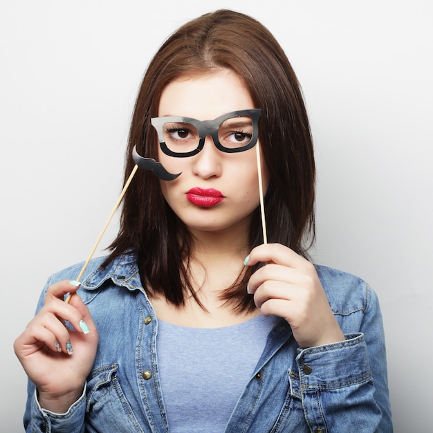 Party image. Playful young woman holding a party glasses. Ready for good time.