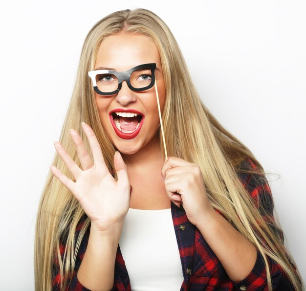 Party image. Playful young woman holding a party glasses. Ready for good time.