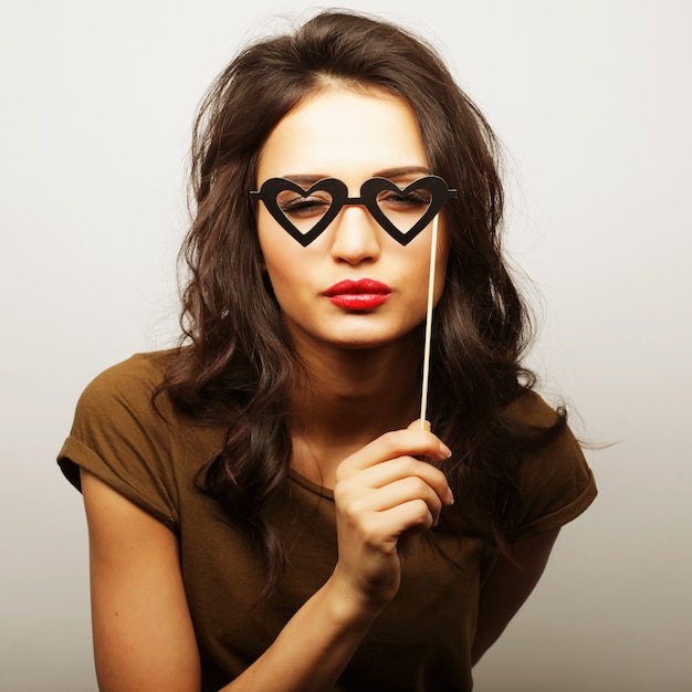 Party image. Playful young woman holding a party glasses. Ready for good time.