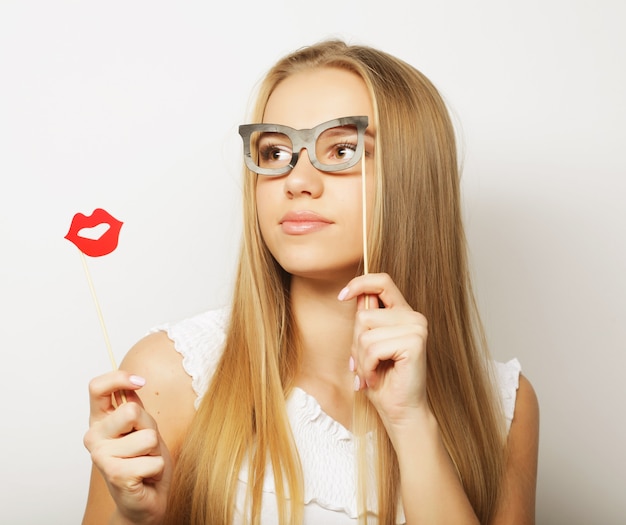 Party image. Playful young woman holding a party glasses.