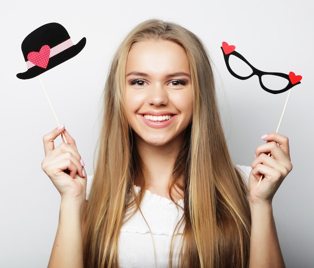 Party image. Playful young woman holding a party glasses.