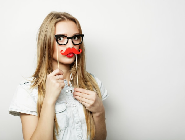 Party image. Playful young woman holding a party glasses.