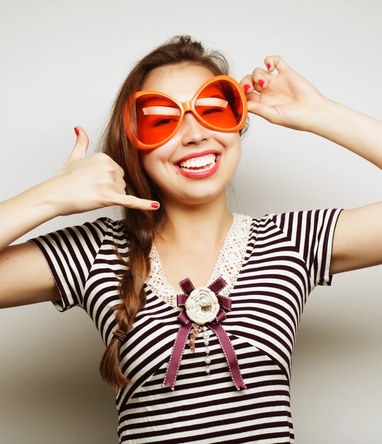 Party image. Playful young woman with big party glasses and crown. Ready for good time.