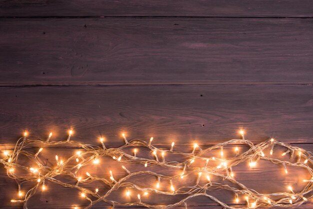 Party lights decoration Wooden background with christmas lights garland