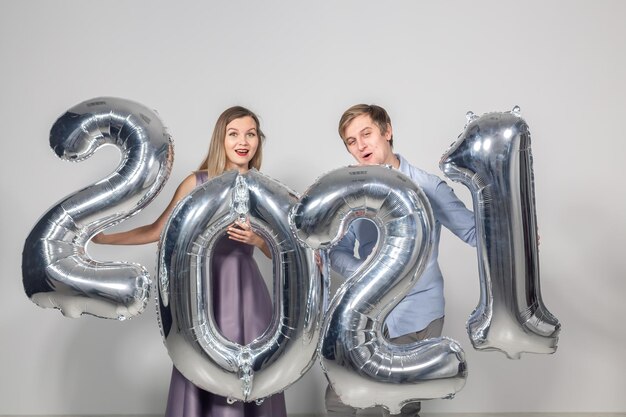 Party, people and new year holidays concept - woman and man celebrating new years eve 2021