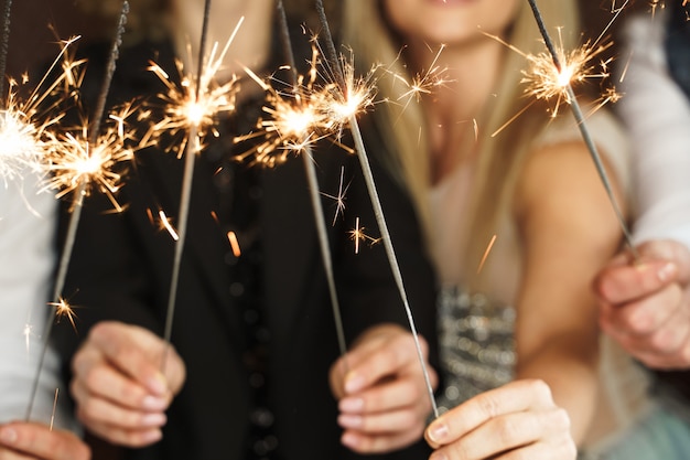 休日やイベントを祝う燃える線香花火でパーティーの人々。カメラは線香花火に焦点を合わせます。