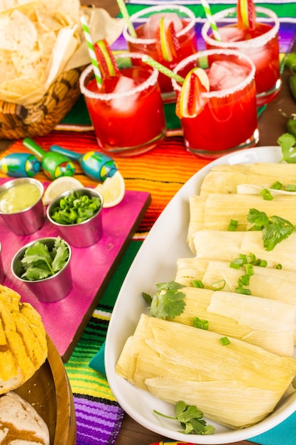 Tavolo da festa con tamales, margarita alla fragola e pan dulche.