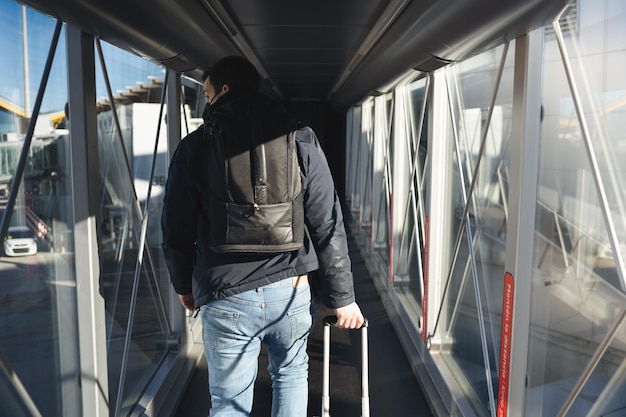 Pasajero bajando del avin con sus maletas de mano para entrar al aeropuerto