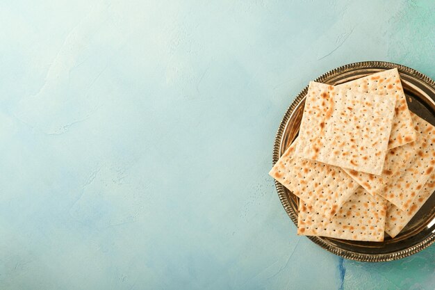 Pascha viering concept Matzah rode koosjer walnoot en lente mooie roze bloemen Traditioneel ritueel Joods brood op licht turquoise of blauwe achtergrond Pascha eten Pesach Joodse feestdag