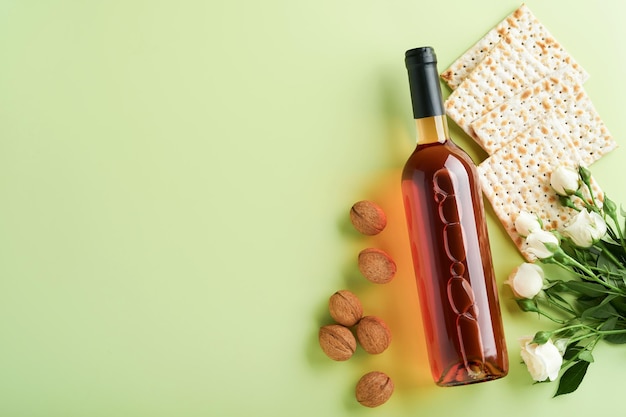 Pascha viering concept matzah rode koosjere wijn walnoot en lente mooie roze bloemen traditioneel ritueel joods brood op lichtgroene achtergrond pascha eten pesach joodse feestdag