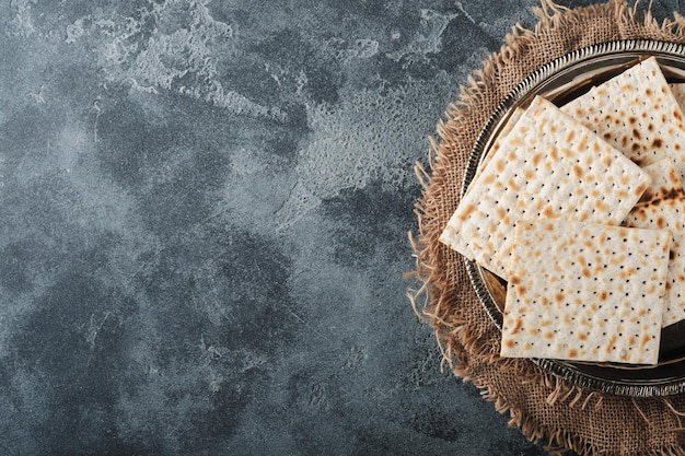 Pascha viering concept Matzah rood koosjer en walnoot Traditioneel ritueel Joods brood op oude donkergrijze betonnen achtergrond Pascha eten Pesach Joodse feestdag