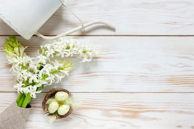 Pasen achtergrond decoratie paaseieren in de nest gieter pot en witte lente bloemen hyacint bovenaanzicht close-up plat leggen