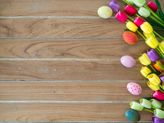 Pasen-achtergrond met kleurrijke eieren en tulpen