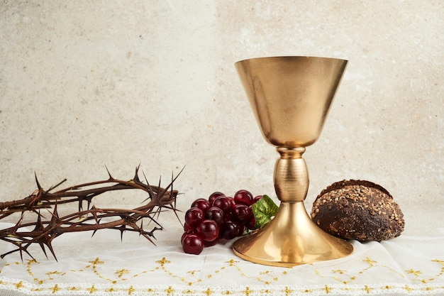 Pasen-achtergrond met kroon van doornen en kelk met rode wijn als concept voor christusbloed