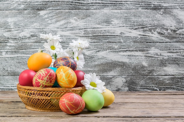 Pasen beschilderde eieren en bloemen op houten rustieke tafel