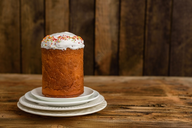 Pasen-cake en kleurrijke eieren op een houten lijst.