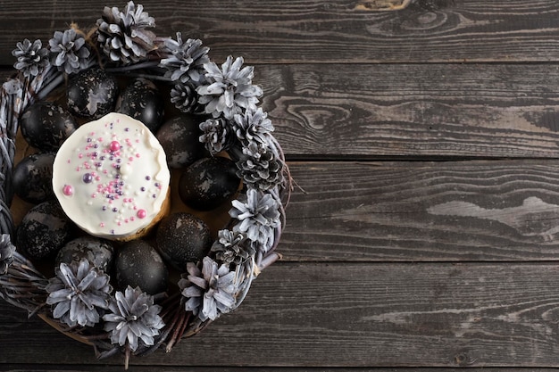 Pasen-cake met gekleurde eieren op donkere houten achtergrond