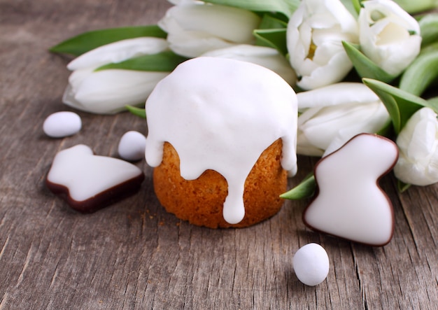 Pasen-cake, witte tulpen, chocoladekonijntje en eieren op een houten achtergrond. Ruimte kopiëren.