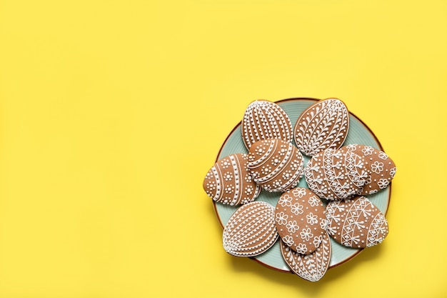 Pasen-koekjes op een plaat op een gele achtergrond. uitzicht van boven. plaats voor tekst. paas eieren.