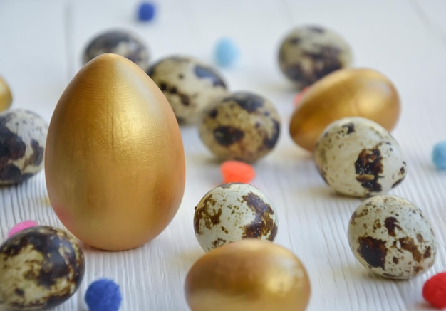 Pasen paaseieren kip en kwartel goud en natuurlijke kleur op een witte houten achtergrond met ruimte voor tekst Card