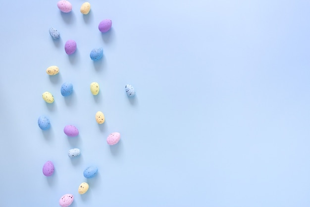 Pasen plat lag met gekleurde eieren op blauw