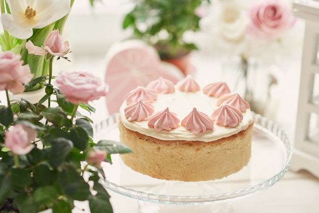 Pasen-samenstelling met zoete cake met aardbeisuikerglazuur en rozen