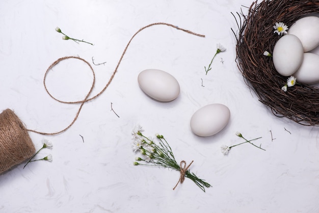 Pasen vieren in de lente. Een nest met vijf witte paaseieren in huis.