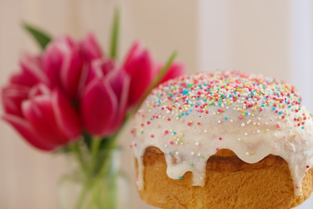 Pasen-voedsel. Pasen-cake met boeket van roze tulpen