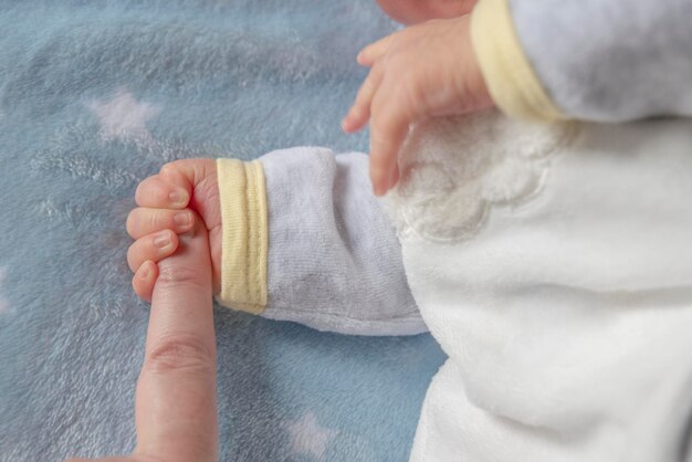 Pasgeboren baby die moeders vinger vasthoudt
