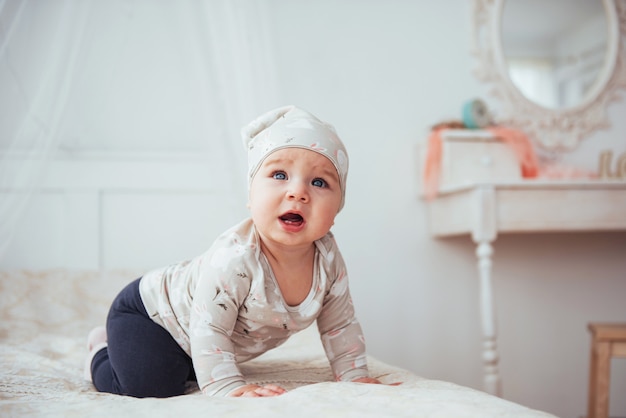 Pasgeboren baby gekleed in een pak op een zacht bed.