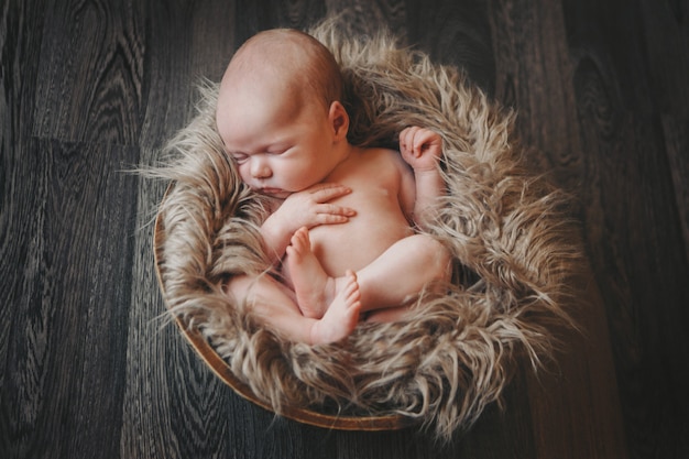 Pasgeboren baby gewikkeld in een deken slapen in een mand.