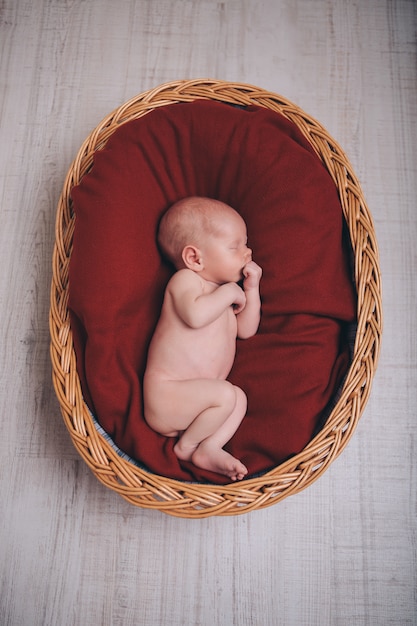 Pasgeboren baby gewikkeld in een deken slapen in een mandje