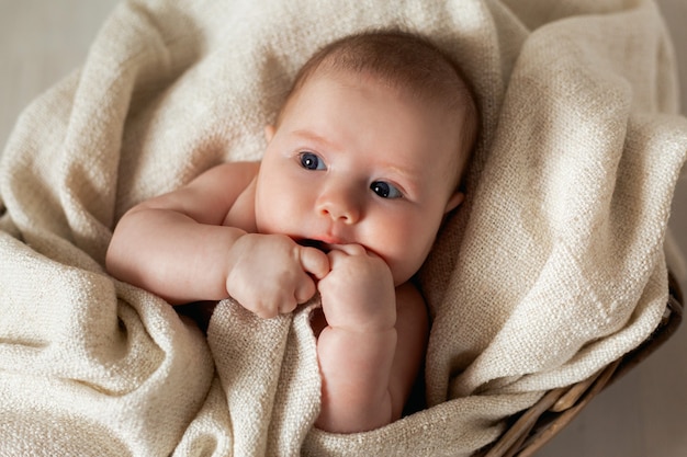 Pasgeboren baby gewikkeld in een linnen deken ligt in een rieten mand wieg producten voor kinderen