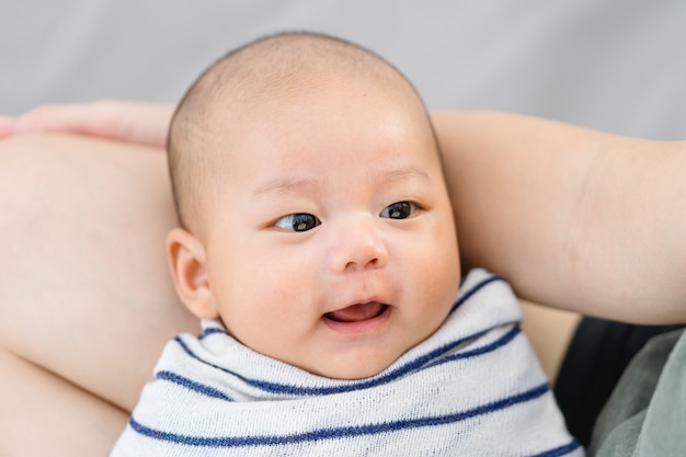 Foto pasgeboren baby glimlach en moeder op zoek