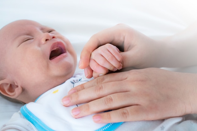 Foto pasgeboren baby huilt met troostende moeder