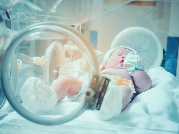 Pasgeboren baby in couveuse in de postverloskamer van het ziekenhuis