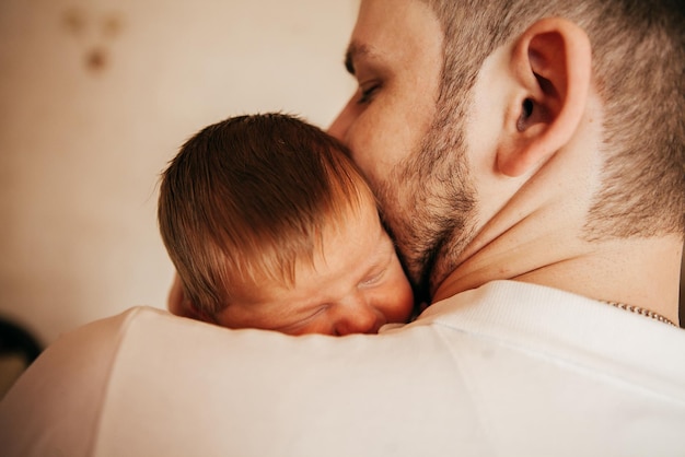 Pasgeboren baby in de armen van jonge ouders