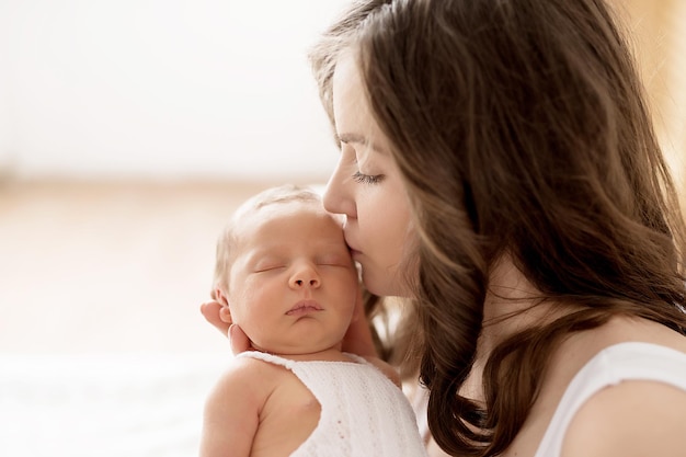 Pasgeboren baby in moeders armen op bed Ansichtkaart Moederdag Beschermingsdag Wereldgeluksdag Glimlachend kind en vrouw