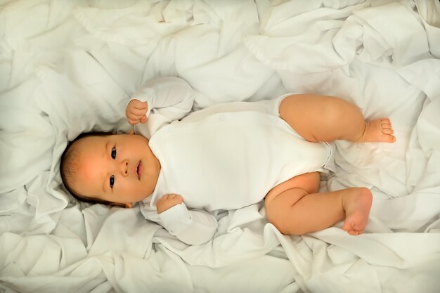 Pasgeboren baby lacht en lacht toont emoties baby ligt op een witte doek